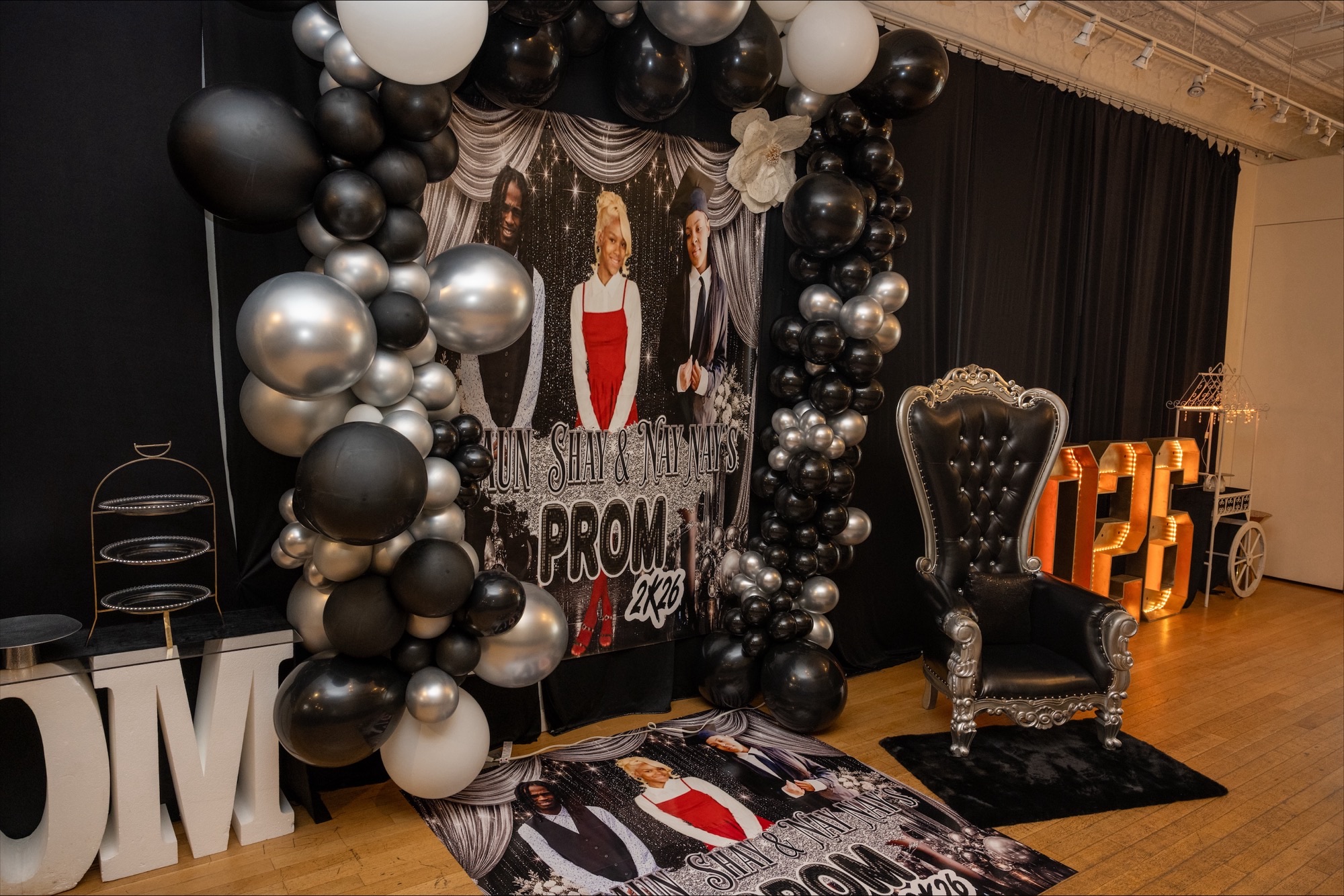Gallery photo of a prom backdrop with balloon decor and throne chair